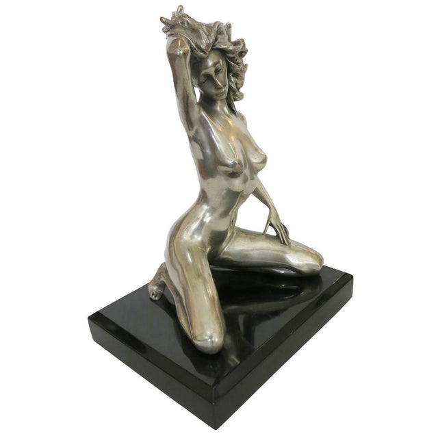 1970s style erotic bronze re-cast of a kneeling nude young girl with one hand resting against her wind-blown hair, one...