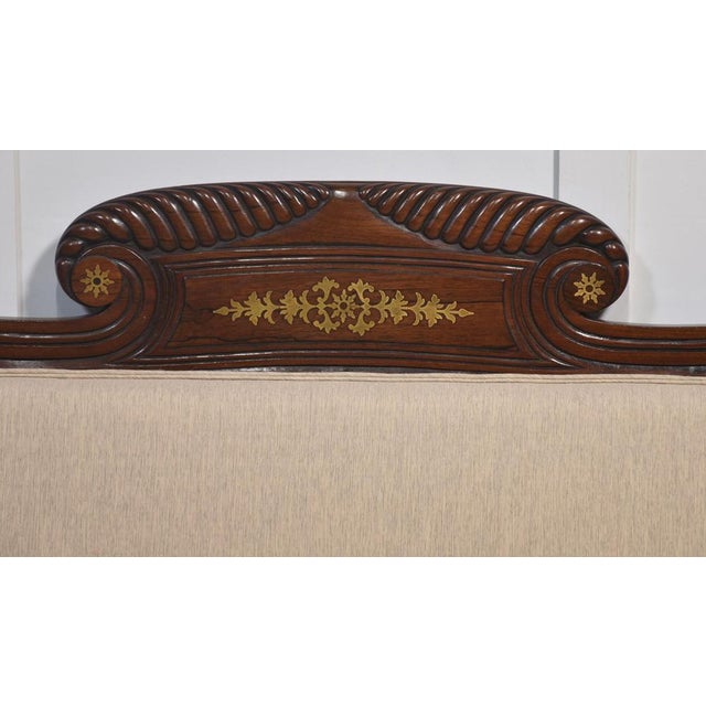 Early 19th-century mahogany framed scroll end settee, the acanthus scrolling arched top rail with brass detail above back...
