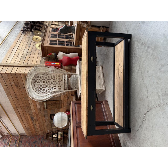 This antique fir console table has been fully restored. It features a black-patinated frame and two raw wood shelves. It...