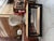 This antique fir console table has been fully restored. It features a black-patinated frame and two raw wood shelves. It...