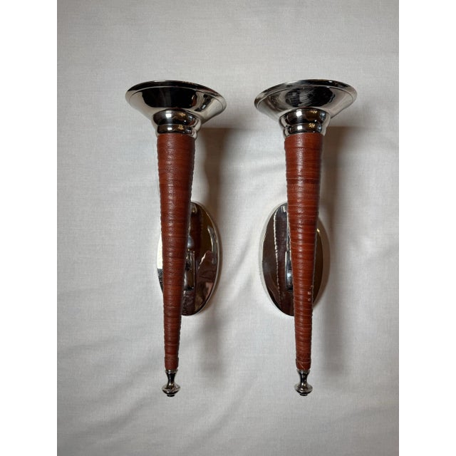 The sheen of the polished chrome cups of the candle holder along with the texture of the leather make this pair an...