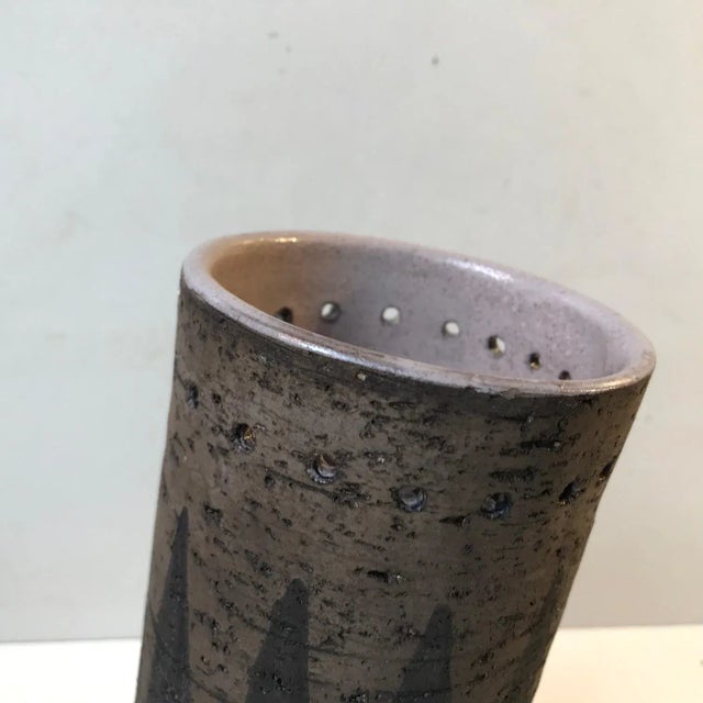 Unusual and unique cylindrical vase in chamotte clay. Partially unglazed exterior decorated with black arrow and see-...