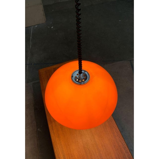 Rare train pendant lamp from Guzzini. The large plastic shade is designed in orange. The screen is white on the inside....