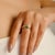 This elegant solitaire wave ring showcases a 1 carat octagon-cut natural emerald, weighing 0.54 carats, set in rich 14K...