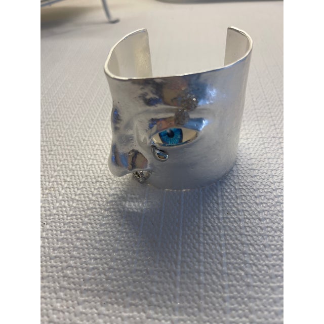 silver evil eye wide cuff bracelet with sculptured nose and eye.2 1/2" wide , 6 1/4" opening
