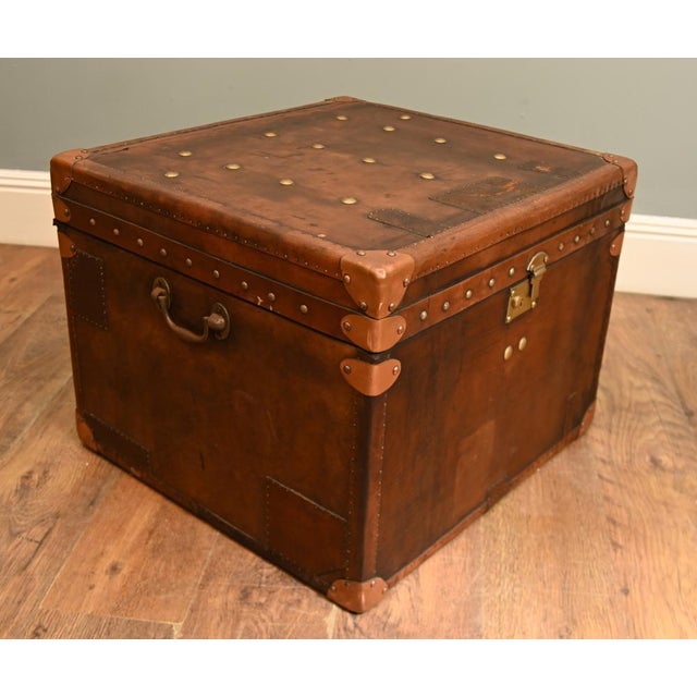 Handsome vintage leather travelling trunk designed in the traditional steamer and campaign luggage style The substantial...