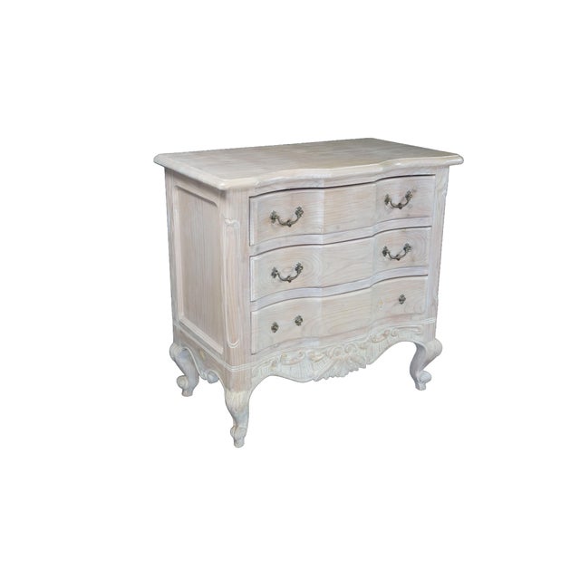 A stunning vintage French Provincial style pickled oak commode or dresser beautifully showcases a romantic, light-toned...
