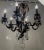French wrought iron and crystal six arm chandelier. Gold over black cage style frame taking on the form of a hot air...
