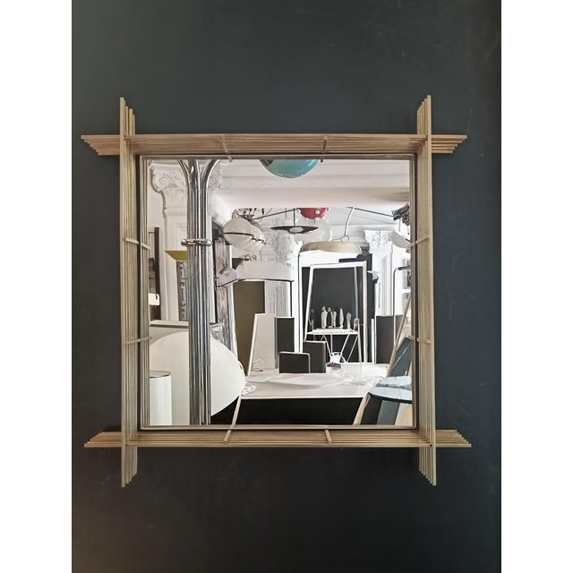 A designer wall mirror with a textured brass frame comprising a grid of slender intersecting rods. In the style of Ettore...
