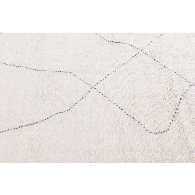Hand-knotted in Morocco, this exquisite contemporary Moroccan rug captures the essence of timeless tribal minimalism while...
