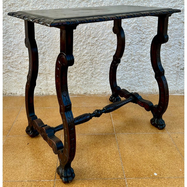 Spanish oak side table dating from the 1920s–1930s. It features a rectangular top with a carved molded edge, elegantly...