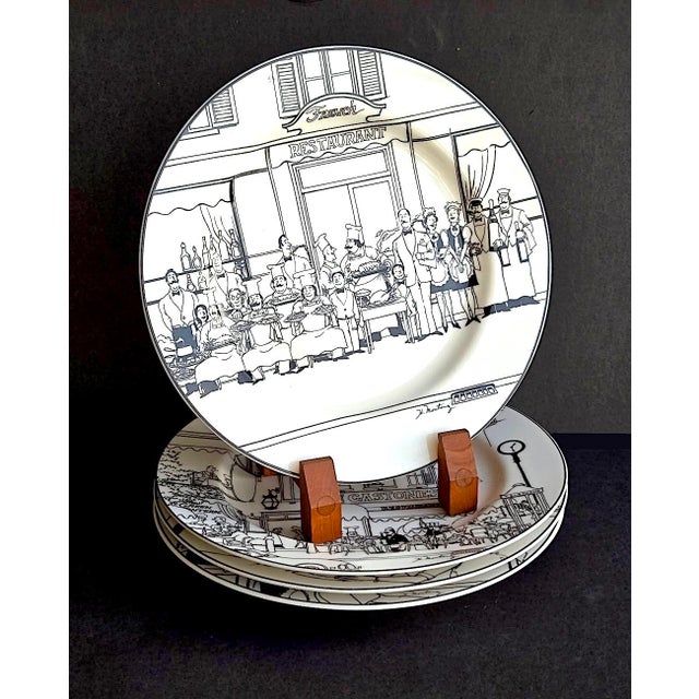 Offered is a charming set of 4 dinner plates depicting illustrations of French restaurant scenes. These whimsical, black-...