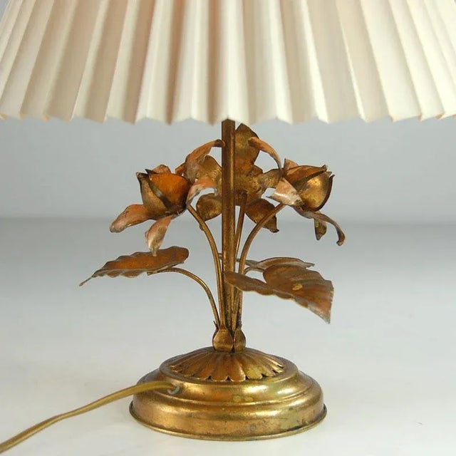 Decorative table lamp made of gold and patinated metal sheet. A bulb holder with E14 thread. Connector on the cable....