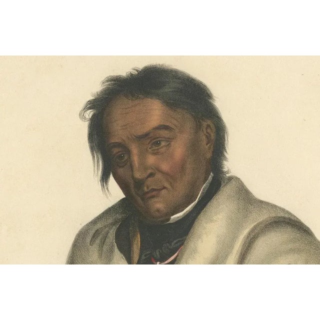 Ojibwe Warrior Portrait – Meta-Koosega, Hand-Colored Lithograph, c.1838 The Stoic Warrior: Meta-Koosega of the Ojibwe This...