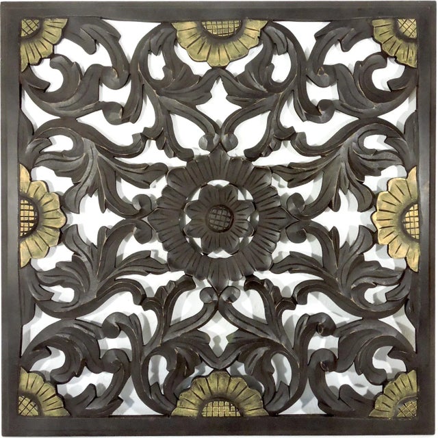 Intricately crafted square expresso brown wall panel that depicts a central flower medallion - a lotus - surrounded by a...