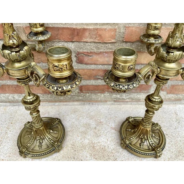 A pair of four-light gilt bronze Louis XVI style candelabra or table lamps. Each one with a fluted shaft that supports the...