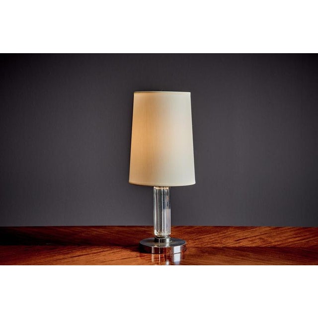 French art deco table lamp by g. Humbert, crafted with a fluted clear glass column, chrome-plated base, and brass details....