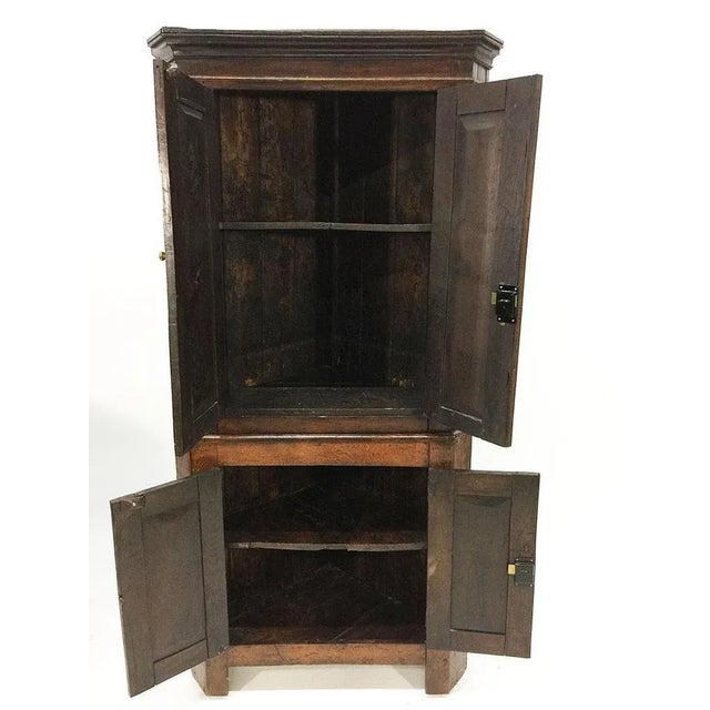 An Dutch early 19th century oak 2-part corner cupboard A Dutch early 19th century oak 2-part corner cupboard, 4 panel door...