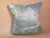 A pillow made from a woven green and cream silk and linen fabric, edged and backed with hand-dyed linen damask. A down...