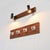 Wall-mounted coat rack composed of a mahogany-veneered plywood panel, to which four aluminum hooks are attached. This...