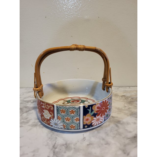 Arita Imari porcelain bowl displays frames alternating panels of floral motifs in iron red, cobalt, and gilt. Each hand-...