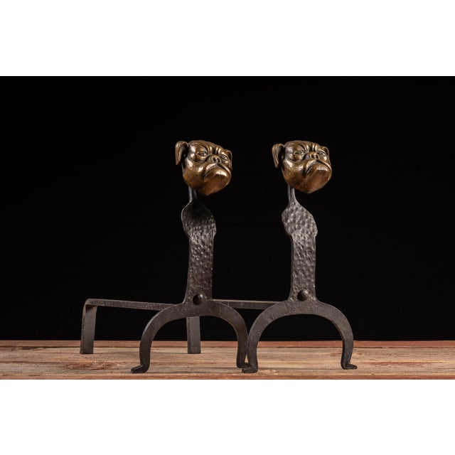 Pair of antique figural fireplace andirons constructed from forged and hammered iron. Each upright standard terminates in...