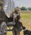 In "Trails End," a solitary figure sits on a wagon, cradling a dog while two others approach, creating a sense of...
