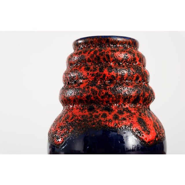 This one is not subtle and has no intention of being. A bulbous navy base rises into a ridged, textured neck completely...
