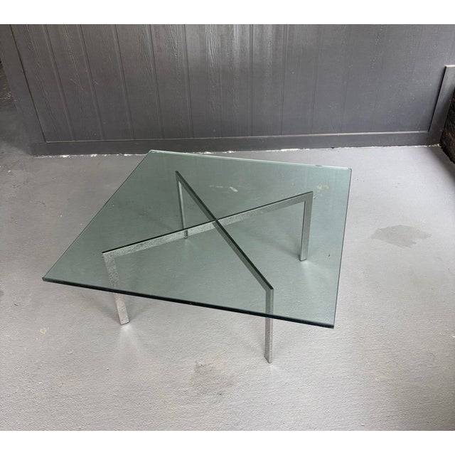 Striking Barcelona-style coffee table in the tradition of Ludwig Mies van der Rohe. Features a square plate glass top with...