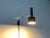 Mid Century wall lamp from Cosack in chrome and black. A minimalist design. The light head shows a simple radiant form...