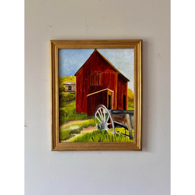 Vintage framed oil painting of a colorful farm landscape with barn and wheel on canvas board in a gold gilt wood frame.