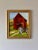 Vintage framed oil painting of a colorful farm landscape with barn and wheel on canvas board in a gold gilt wood frame.