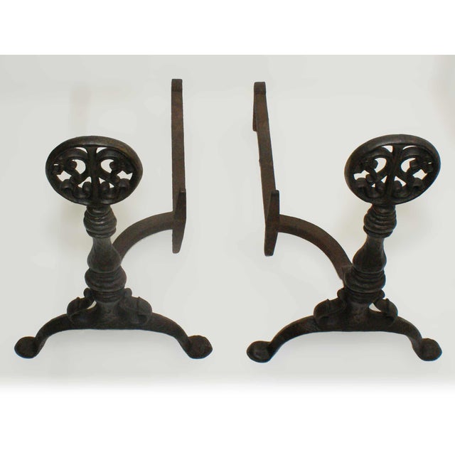 Pair of antique cast iron andirons having dragon medallion finials on turned balusters and splayed feet. Circa 1915.