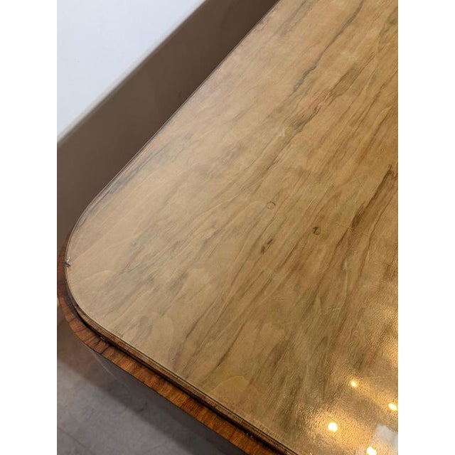 Elegant Art Deco dining or conference table featuring a richly figured walnut veneer base and a protective glass top. This...