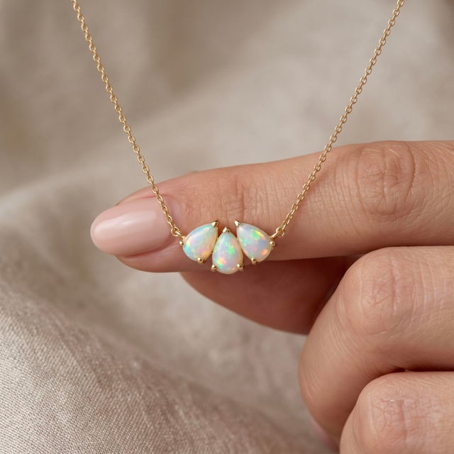 Illuminate your style with this enchanting cluster pendant necklace, featuring three shimmering white gemstones that catch...