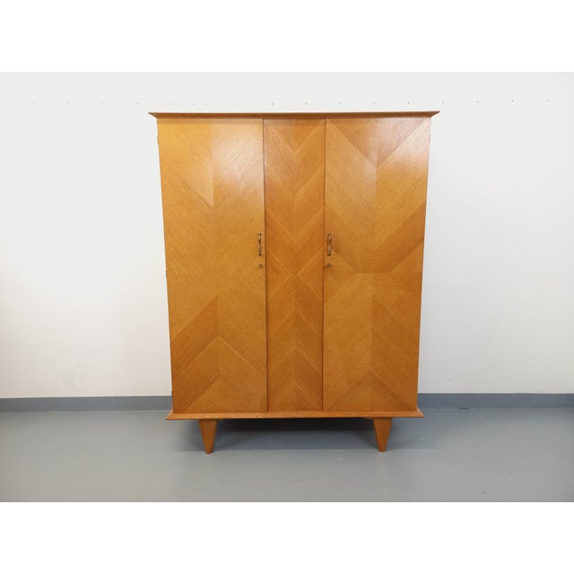 Vintage 1960s wardrobe in oak with geometric marquetry, splayed legs, ample storage: two doors with two handles and brass...