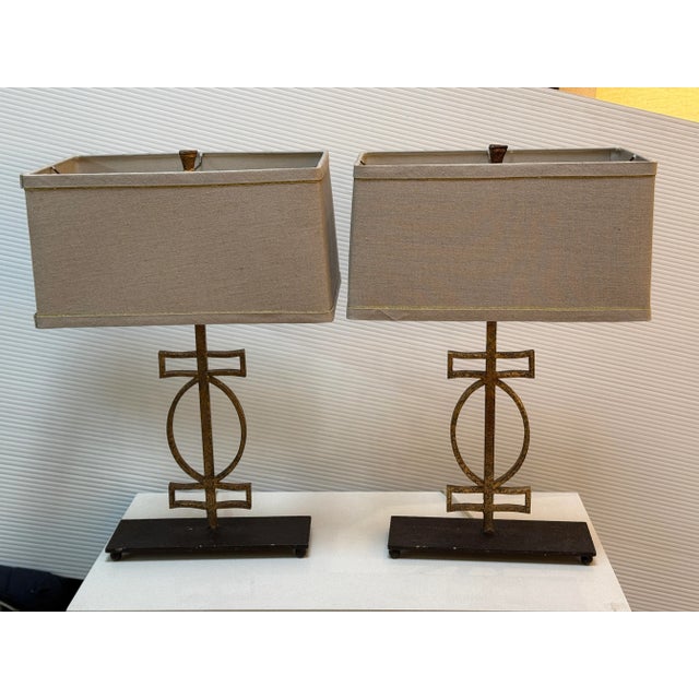 Design Plus Gallery presents a pair of Gabby Home Annette Table Lamps. Black wrought iron pedestals support splattered...