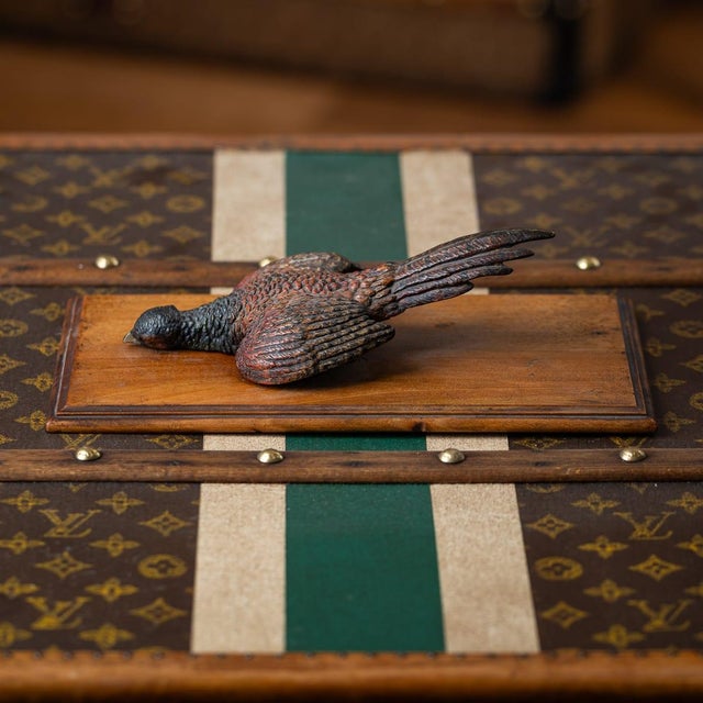 A 20th century cold-painted bronze wall-mounted document holder / paper clamp on a wooden backing. A hinged pheasant...