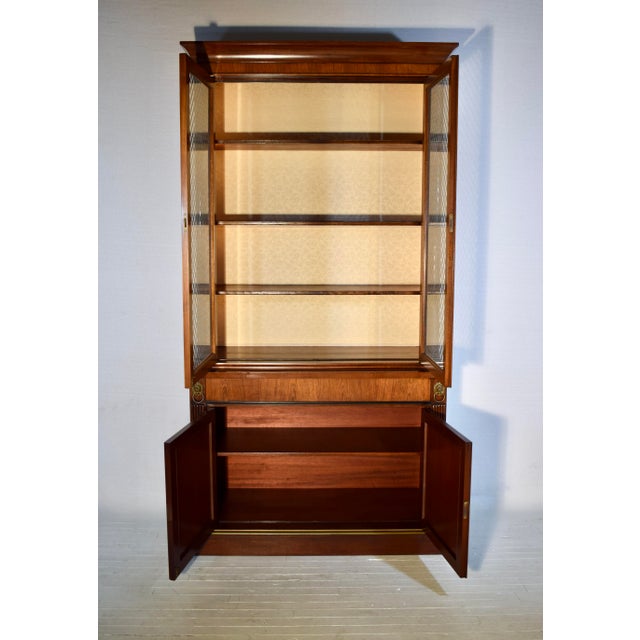 A fine Regency 20th c. banded Mahogany two part bookcase cabinet vitrine. Features to the top include the handsome...