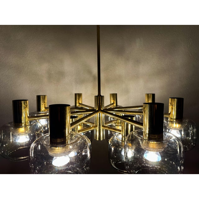 Beautiful mid - Century design. 1970s large chandelier made by German Kaiser Leuchten. Sleek geometric brass frame with 12...