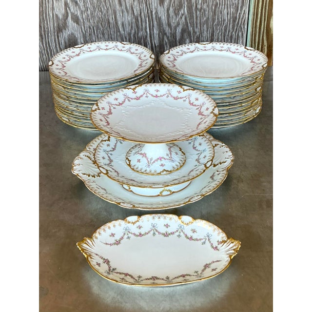 This exquisite 30-piece Limoges china set showcases timeless Regency-era elegance with its delicate floral swag motifs,...