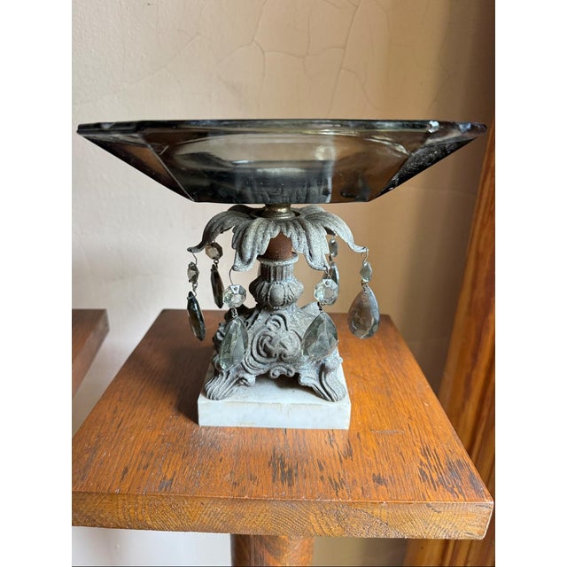Mid-century Hollywood Regency pedestal centerpiece bowl featuring a thick smoky-gray molded glass dish set on an ornate...