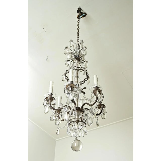 An impressive French six-light brass and crystal chandelier from the 1800s. This chandelier has a dark brass frame with...