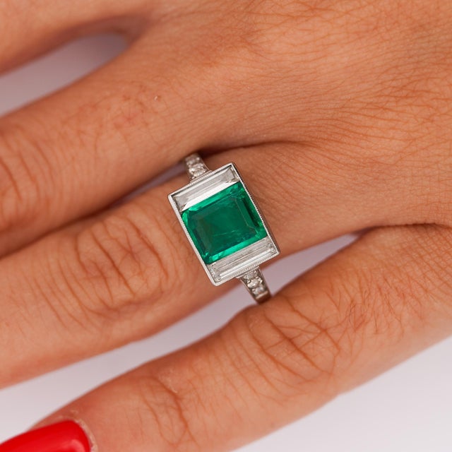 Art Deco platinum ring set with a 1.58 carat Colombian emerald, GIA-certified with no clarity enhancement, flanked by 1.10...