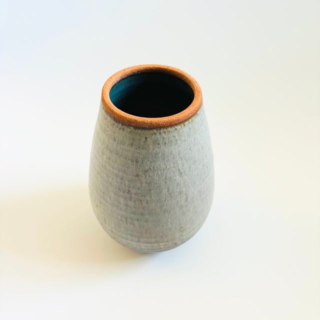 A large vintage hand made pottery vase. Beautiful gray glaze with a slight speckle. Accented by a blue interior and...