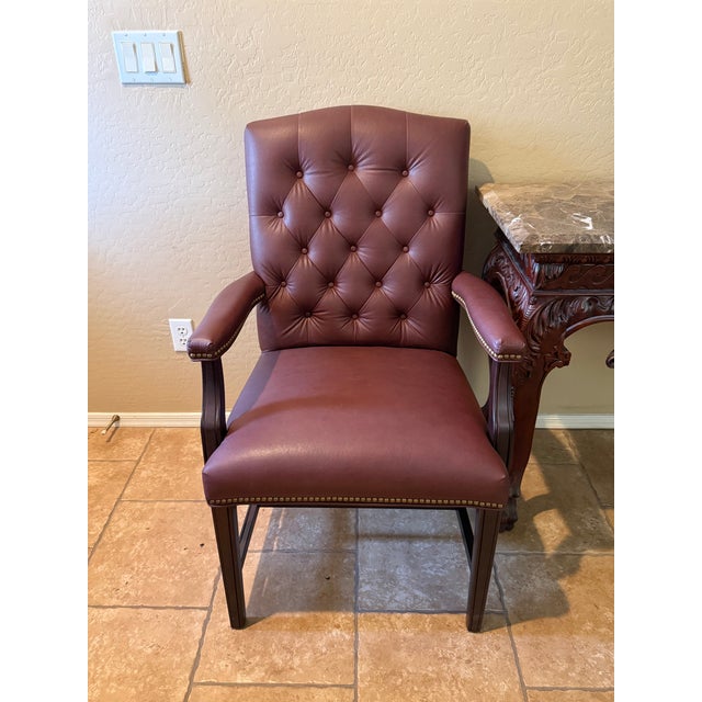 Set of Elegant traditional armchairs featuring deep diamond button tufting, rich burgundy upholstery, brass-tone nailhead...