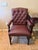 Set of Elegant traditional armchairs featuring deep diamond button tufting, rich burgundy upholstery, brass-tone nailhead...