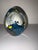 Egg-shaped art glass paperweight with small tropical fish submerged on a blue seabed, height 12 cm, circumference 7 cm