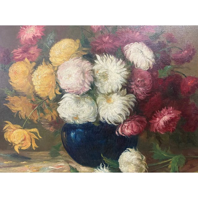 A richly painted floral still life depicting a generous arrangement of chrysanthemums and garden flowers gathered in a...