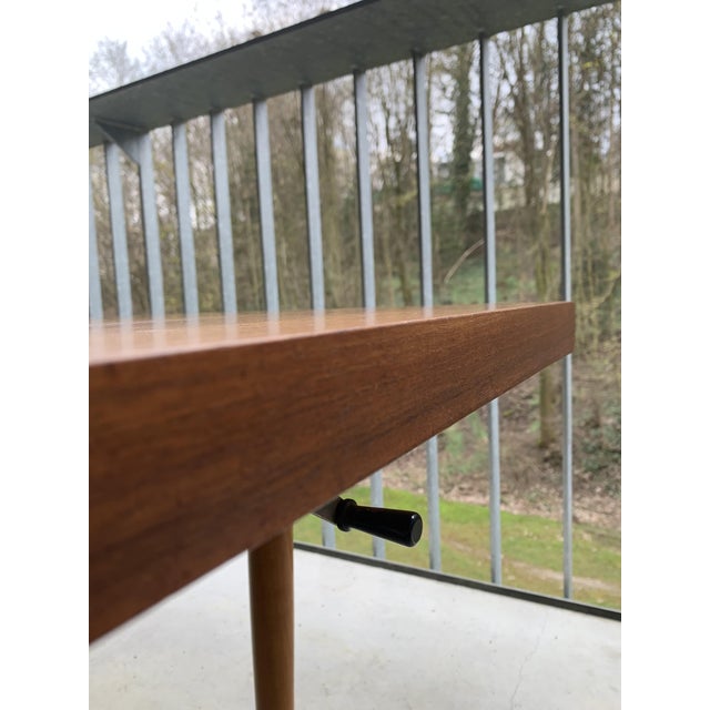 The table is an original piece from the period. Teak veneer. Some scratches and slight discoloration along the edge....